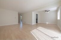 Empty living room with light wood floors and sunlight